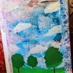 A painting featuring trees and clouds at Carlie's Art Gallery.